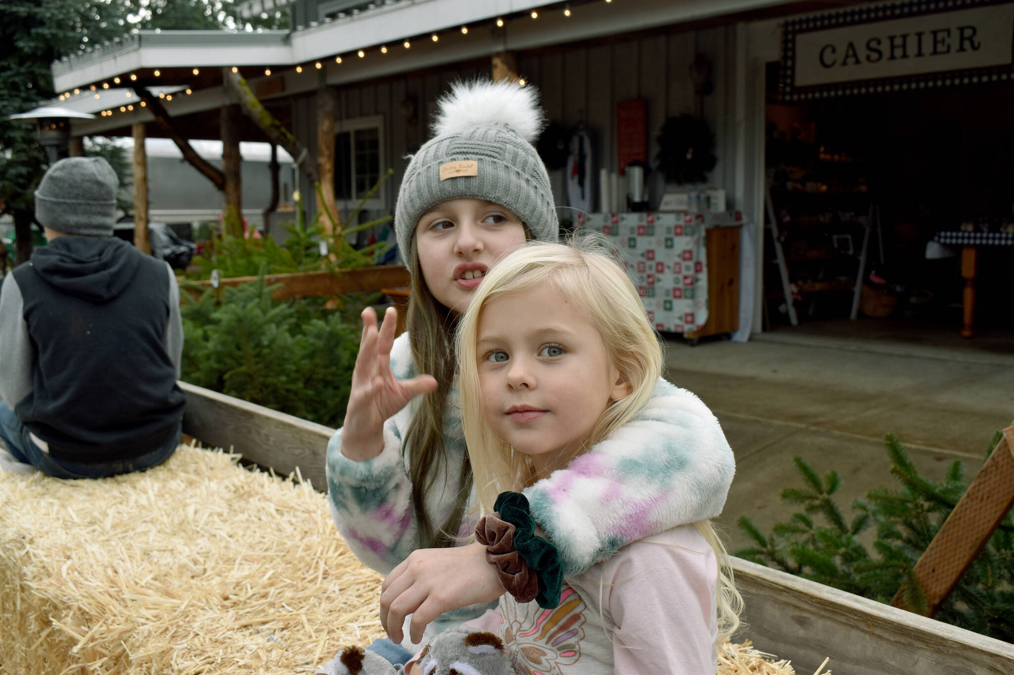 Charlie puts an arm around her little sister Kacey on a hay ride around the tree farm.