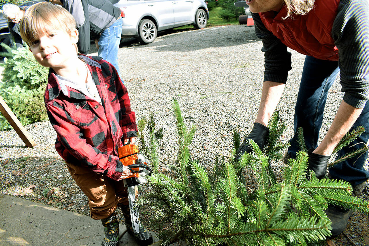 John Ryan Shumway, 3 and a half years old, shows off his toy chainsaw. Photo by Alex Bruell