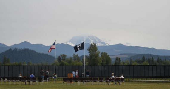 Photos by Alex Bruell 
Mount Rainier rises behind The Moving Wall as its sits in a grassy field near Sunrise Elementary the afternoon of Thursday, Aug. 5.