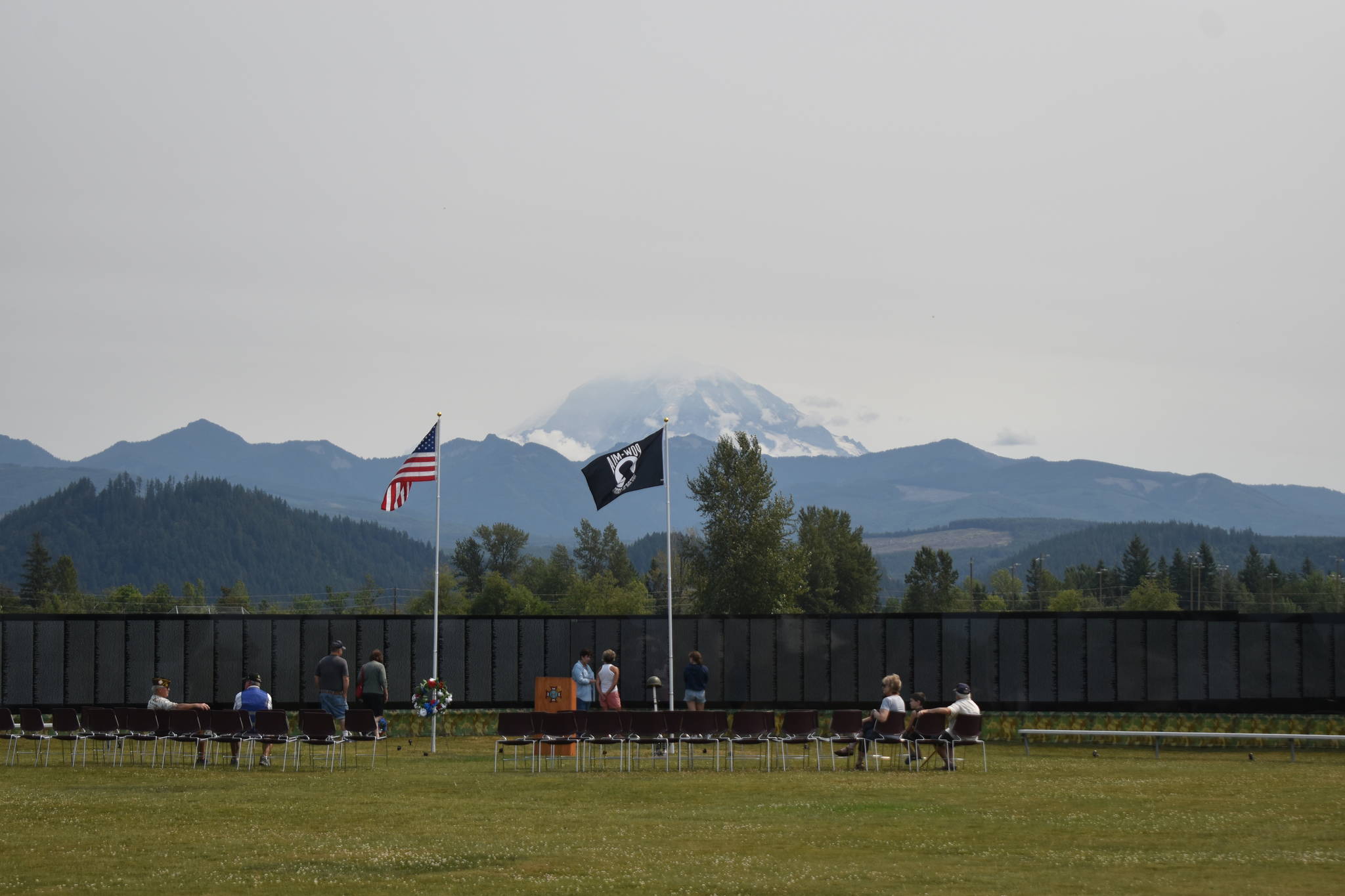 Mount Rainier rises behind The Moving Wall as its sits in a grassy field near Sunrise Elementary the afternoon of Thursday, Aug. 5. Photo by Alex Bruell.