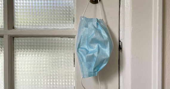 A protective mask hanging on a front door. (Sound Publishing file photo)