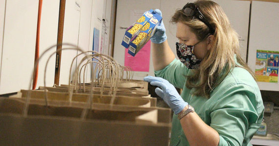 Fiona Drynan, a local volunteer, preparing some pre-packed meals for Enumclaw families needing food from the Enumclaw Food Bank back in 2020, when the pandemic was just getting started. Photo by Ray Miller-Still