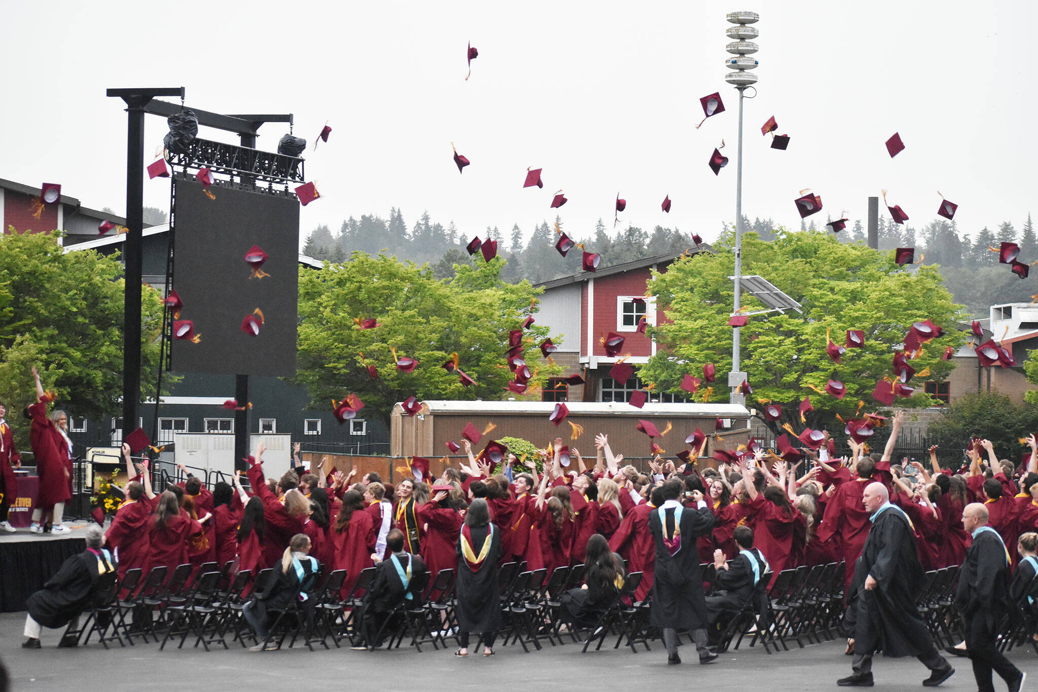 White River graduates toss their caps in the air at the end of their graduation ceremony. Photo by Alex Bruell.