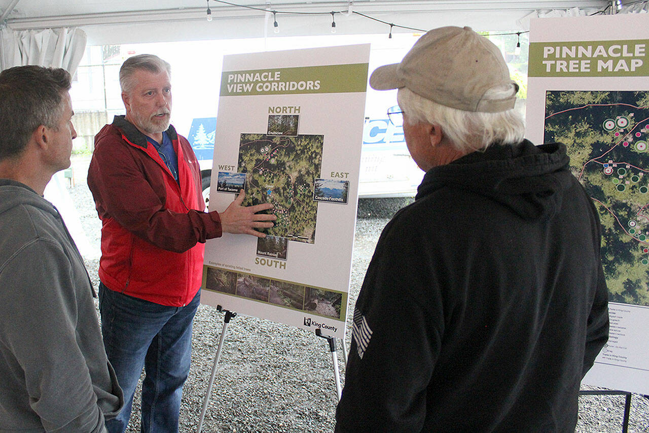 Photo by Ray Miller-Still 
King County’s Community Partnerships and Grants Program manager Scott Thomas talks to a couple locals about the proposed tree cutting plan on Mt. Peak before the official presentation.