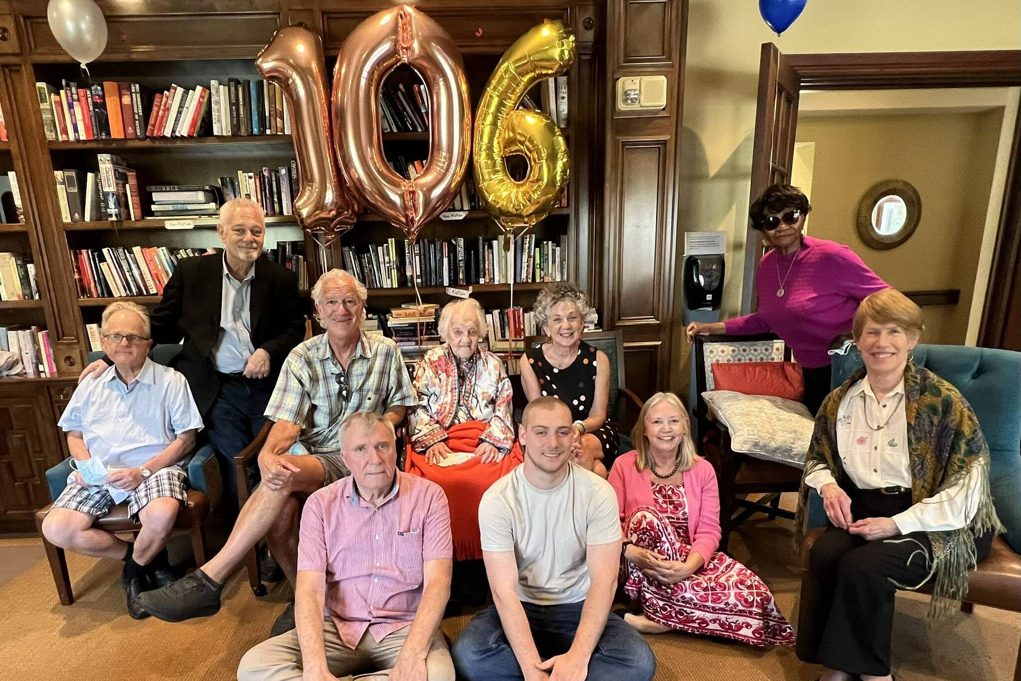 Hilde Bruell’s family and friends sit with her for a photo at her 106th birthday celebration.