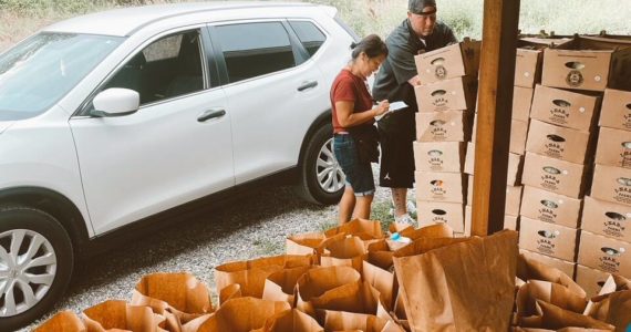 Taylor Larson helps a DoorDash driver load up his car with curated food boxes for customers. Photo courtesy The Market