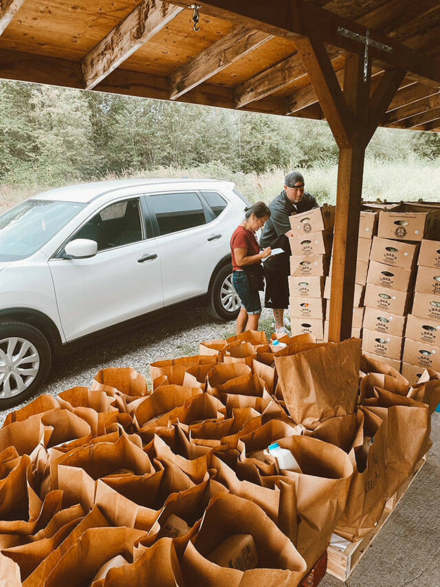Taylor Larsen helps a DoorDash driver load up his car with curated food boxes for customers. Photo courtesy The Market
