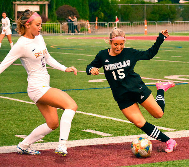 Enumclaw’s Bella Baird winds up to clear the ball from her end of the field while being pressured by White River’s Laura Corr. Photo by Kevin Hanson