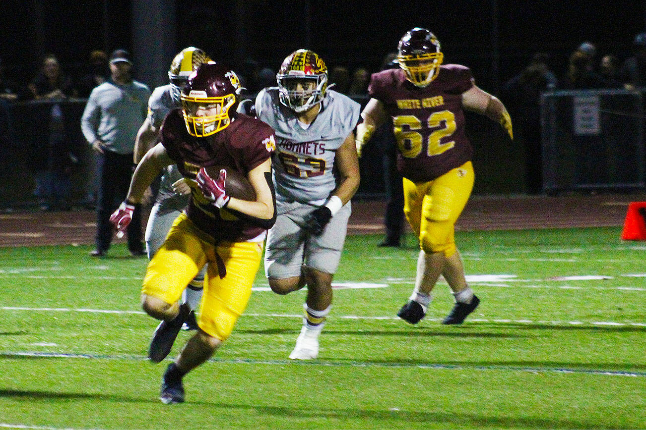 The Enumclaw and White River Hornets met on the gridiron last Friday for the annual Battle of the Bridge. EHS emerged from the melee as the apex insect, but WRHS was able to get a few good stings in. Pictured is WRHS’ Jacob Rennaker making a break after completing a pass from Aaden Rathbun. Photo by Ray Miller-Still