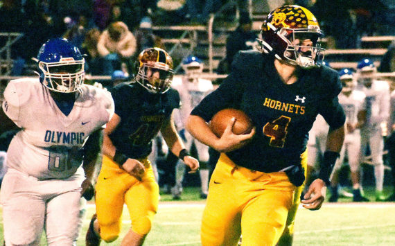 Enumclaw High advanced to the Elite Eight in the state Class 2A football playoffs with a lopsided, Friday night victory over visiting Olympic. Here, Hornet quarterback Gunnar Trachte runs for a first down. Photo by Kevin Hanson