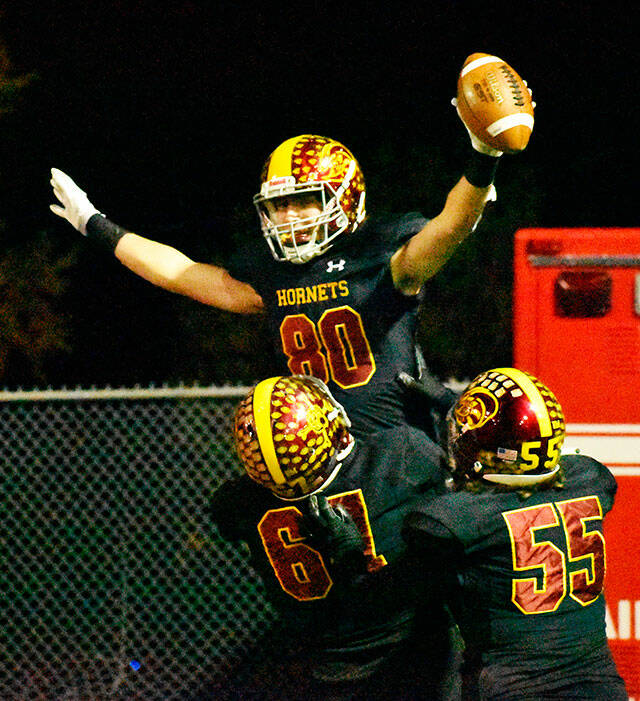 Celebrating a second-half touchdown reception is Karson Holt, getting a boost from linemen Zeke Luchi (67) and Will Harper (55). Photo by Kevin Hanson