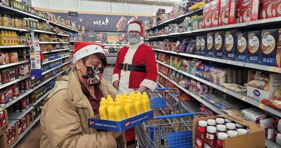 Santa joined the Enumclaw Food Bank in shopping for food and other necessities at WalMart last year, with money raised by Johnathan Monson and Dirty2Dreamy. Contributed photo