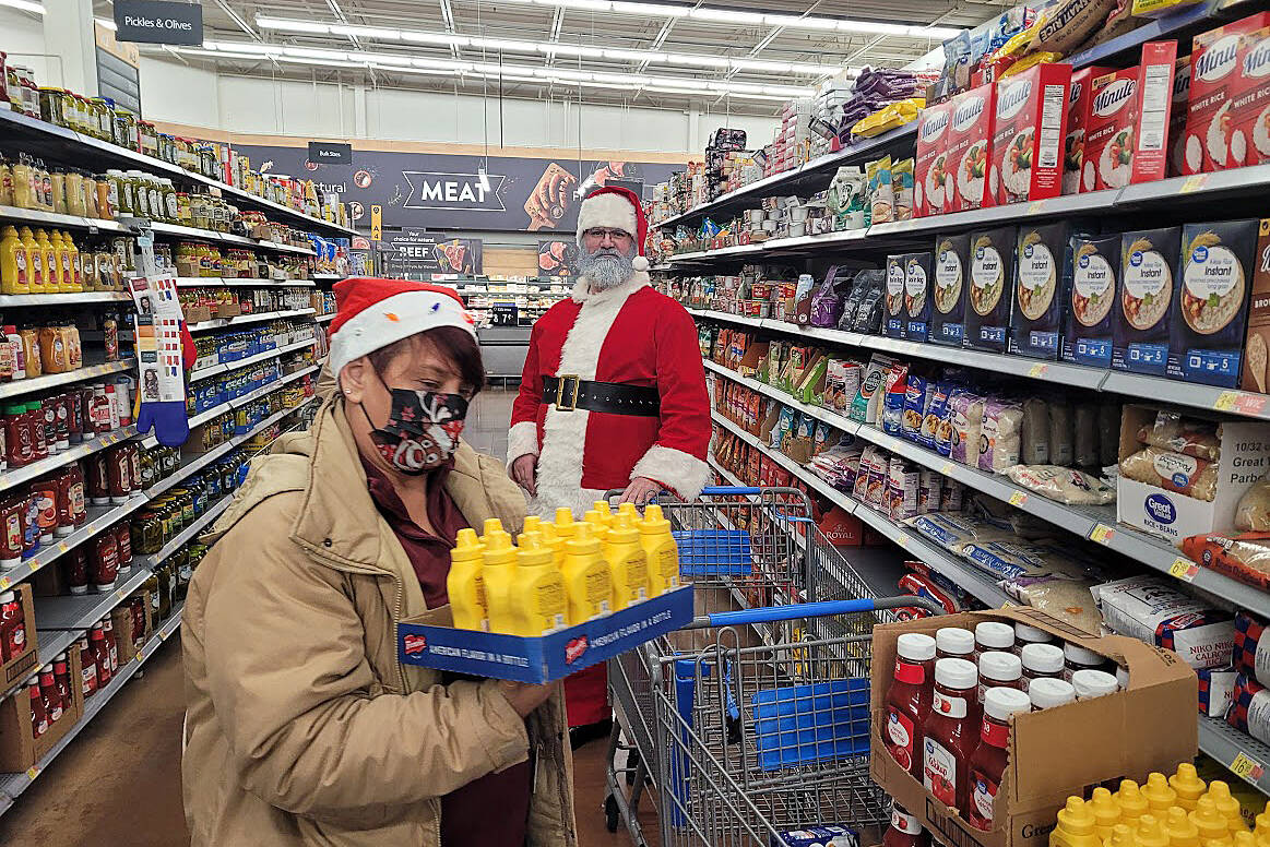 Contributed photo 
Santa joined the Enumclaw Food Bank in shopping for food and other necessities at WalMart last year, with money raised by Johnathan Monson and Dirty2Dreamy.