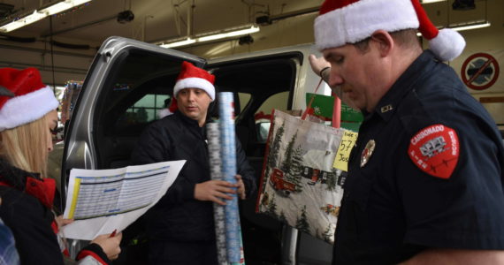Photo by Alex Bruell 
Buckley firefighters check the names on their ‘Nice’ list while loading gifts.