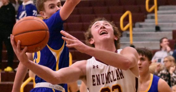 PHOTOS BY KEVIN HANSON The Plateau’s boys’ basketball teams rolled to victories Friday (Dec. 16) night, both playing host to South Puget Sound League 2A opponents. Helping his Enumclaw High team to a victory over the Fife Trojans was senior Ty Hanson (22), shown here working to score under the basket; in the Buckley gym, junior Tyce Donovan (11) races past a Clover Park defender.