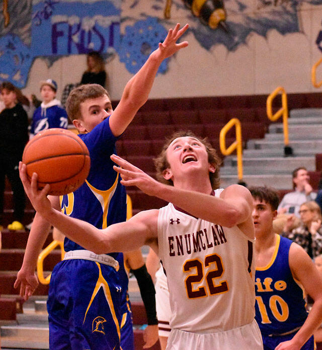 Helping his Enumclaw High team to a victory over the Fife Trojans was senior Ty Hanson (22), shown here working to score under the basket. Photo by Kevin Hanson