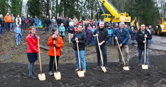 Foothills Rails to Trails Executive Director Shayla Miles, former Buckley Mayor Pat Johnson, former Enumclaw Mayor Liz Reynolds, King County Executive Dow Constantine, Pierce County Executive Bruce Dammeier, and King County Parks and Rec Director Warren Jimenez pose with their ceremonial shovels in front of the crowd gathered at the groundbreaking. Photo by Ray Miller-Still