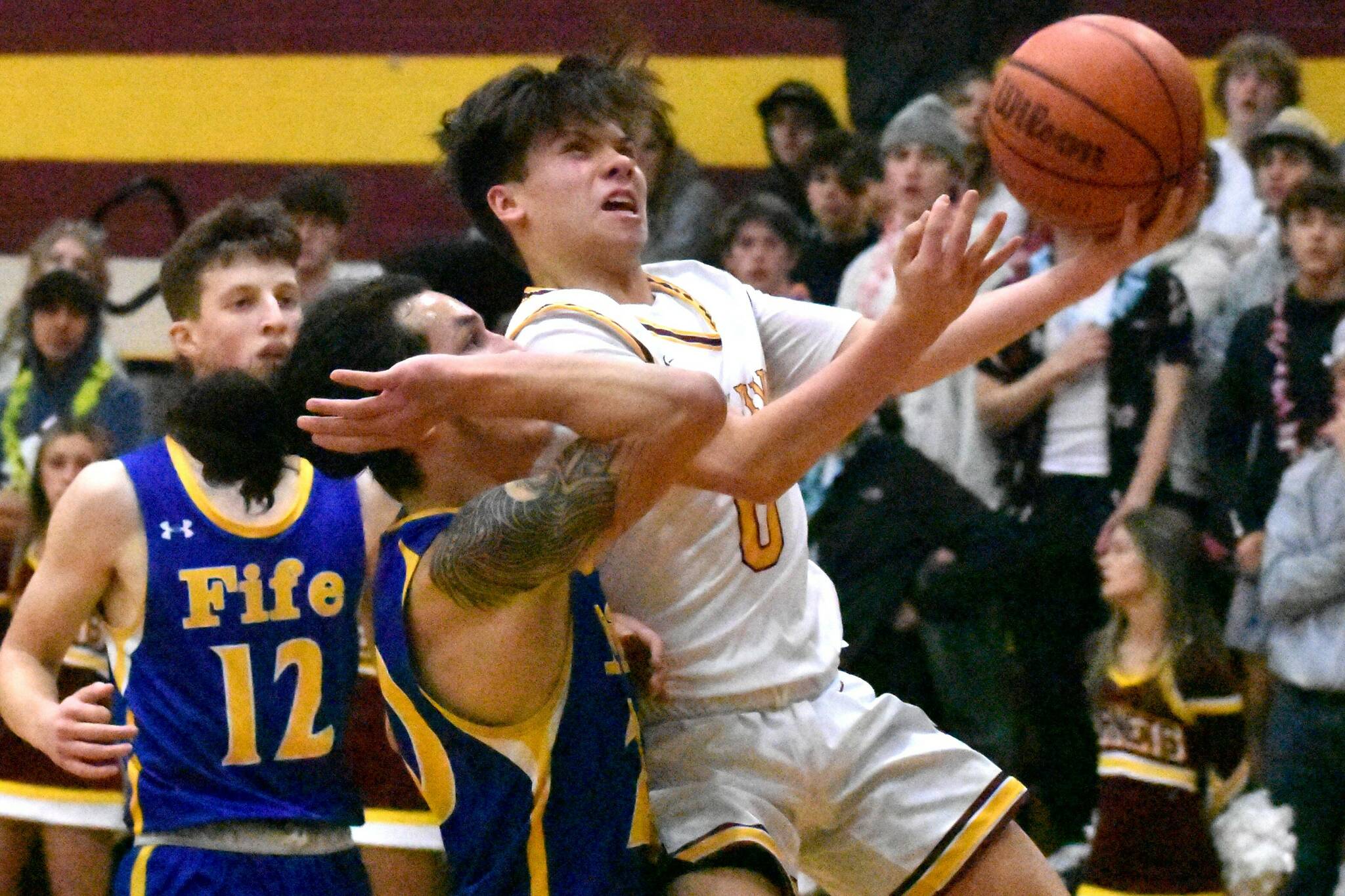 Logan Senon (0) is fouled as he drives through the lane. Details from both games can be found in Sports Roundup. Photo by Kevin Hanson
