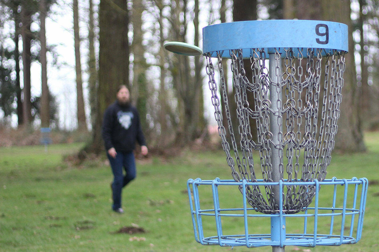 Chris Waugh makes a shot at the No. 9 hole at the Farmer’s Park disc golf course in Enumclaw, which has been upgraded since spring 2022. Residents can take a survey on Enumclaw parks and recreation to determine what other parks could get some TLC. Photo by Ray Miller-Still