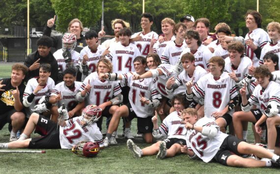 Photos by Kevin Hanson and Todd Overdorf / sonscapeimages.com/home
The Enumclaw High lacrosse team celebrates with a mid-field photo, moments after capturing the 1A/2A state championship. The Hornets took the title with a convincing victory over Orting at the Starfire complex in Tukwila. Pictured here, taken during Saturday’s contest, are McCade Walker (#16) maneuvering past an Orting defender; and Colton Paulson diving toward the goal through three Orting players.