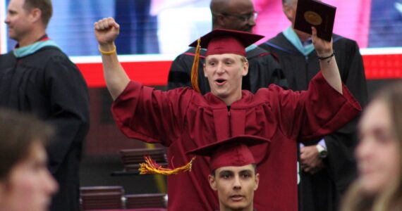 A student celebrates receiving his diploma.