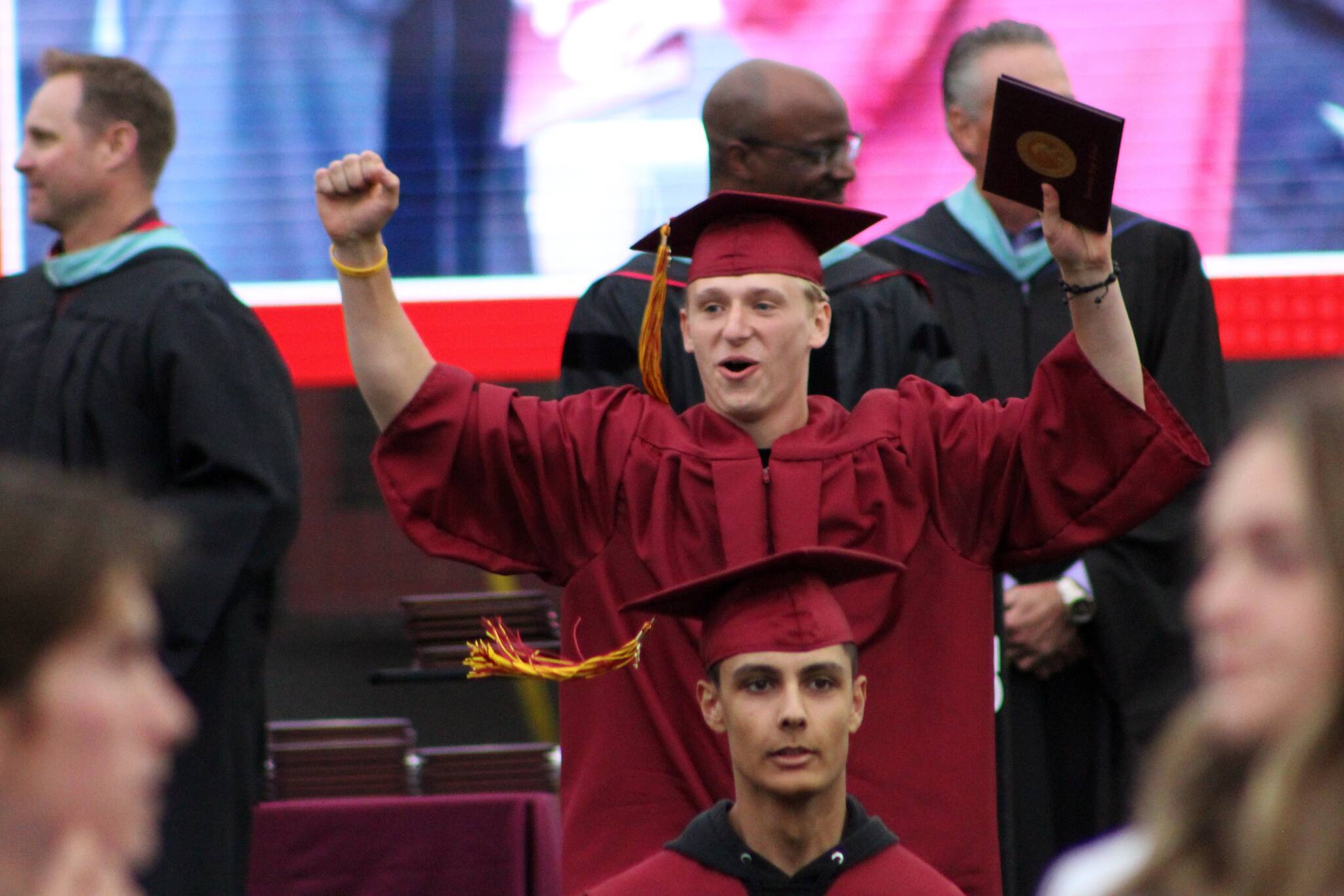 A student celebrates receiving his diploma. Alex Bruell / Sound Publishing.