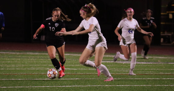 Senior, Anne Anderson, maneuvering away from defenders as she advances downfield. Photo by Andy Orozco