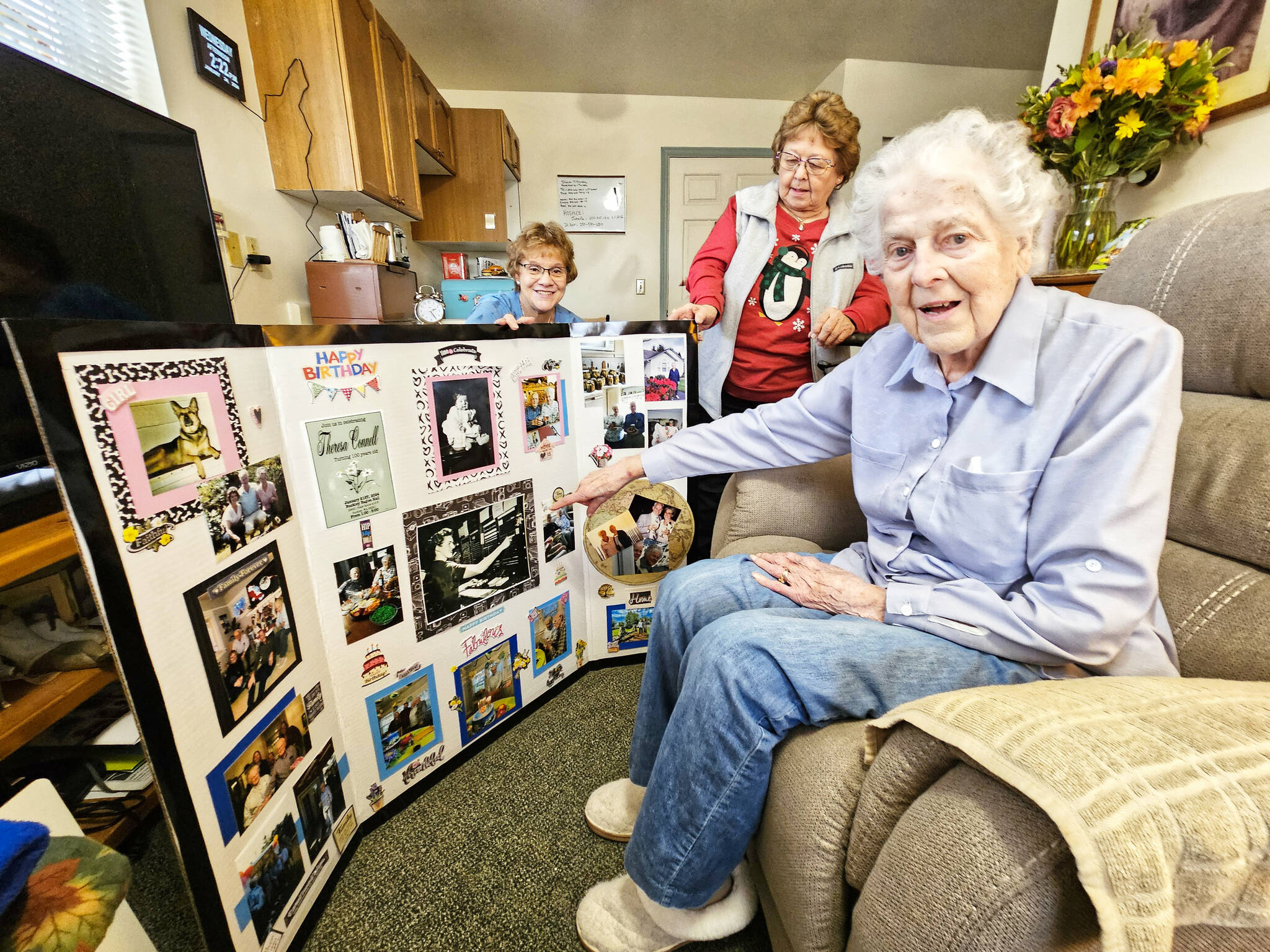 Photo by Ray Miller-Still
Heritage House staff and residents put together a collage of Teresa’s life for her birthday party. Here, Teresa is showing off a picture of her working as a telephone operator.