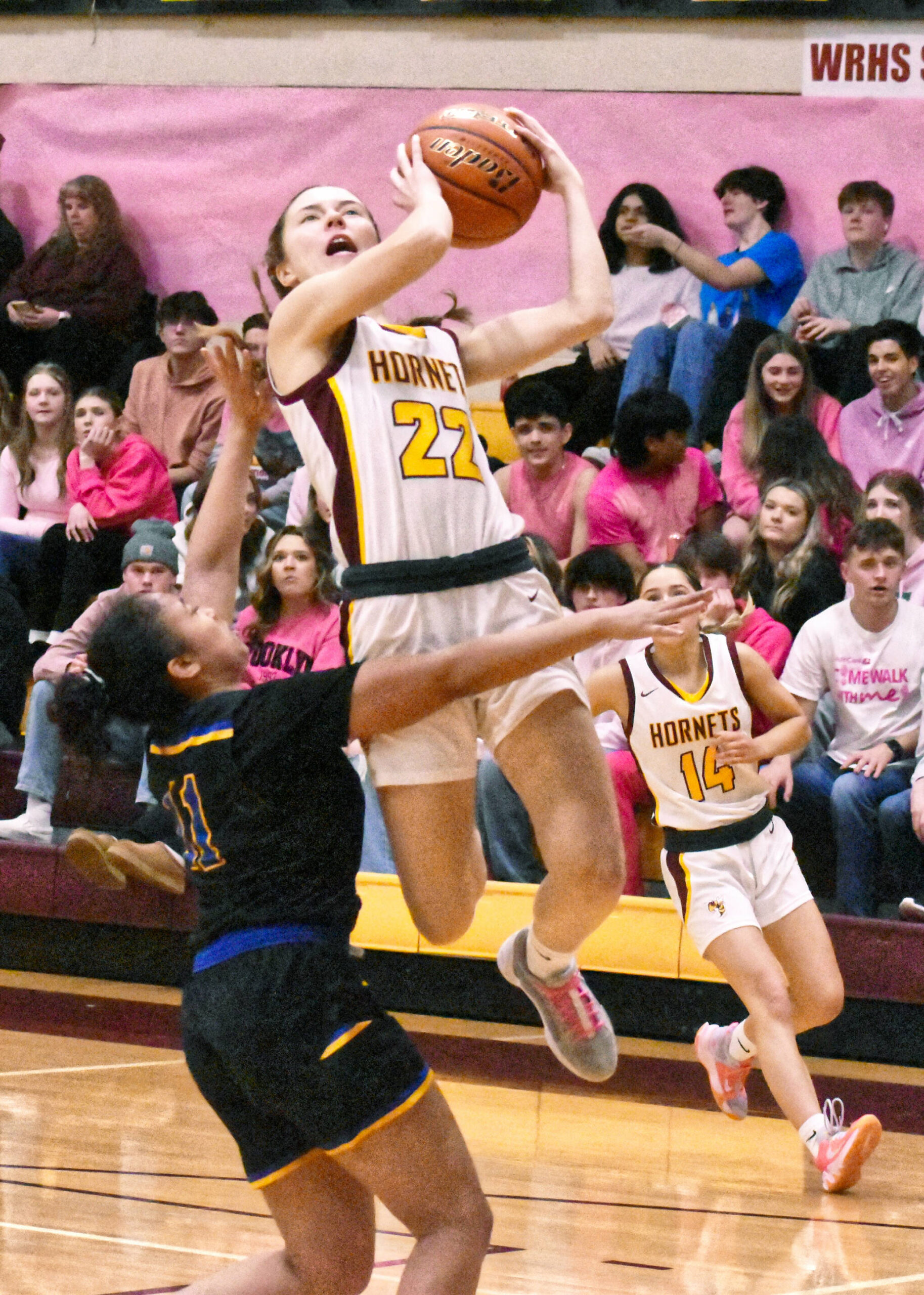 Friday night proved successful for the White River High basketball programs as both the Hornet boys' and girls' teams swept the visiting Fife Trojans. In these photos, White River's Sawyer Bloom (12) looks to score an inside bucket and, on the girls' side, Maggee Schmitz (22) elevates on a drive to the hoop. Photos by Kevin Hanson