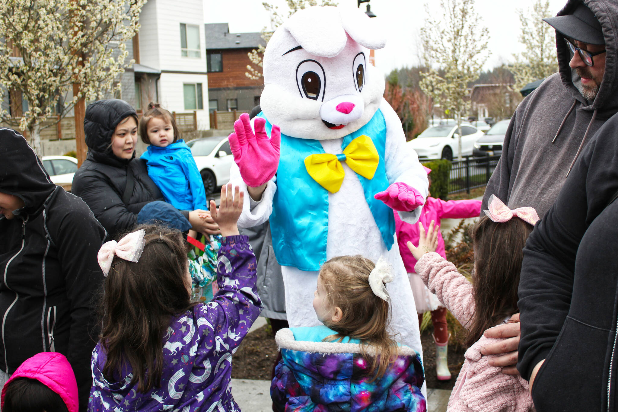 Photo by Ray Miller-Still
Which local Easter egg hunt will you be attending this year? Pictured is a group of sisters high-fiving the Easter Bunny at the Ten Trails event last year. Please note that the neighborhood is not doing an egg hunt this year, but will be hosting an Easter Carnival.