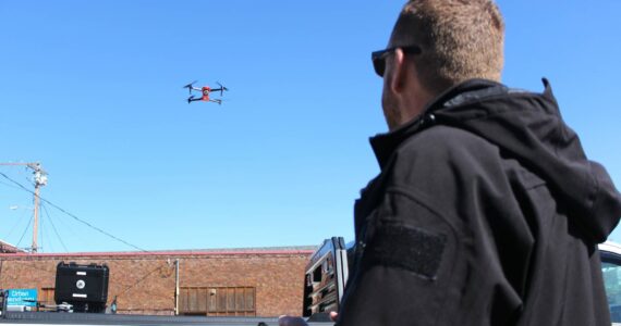 Enumclaw Police Deparment's Commander Mike Graddon flying "Thunderbird," his bright orange drone. Photo by Ray Miller-Still