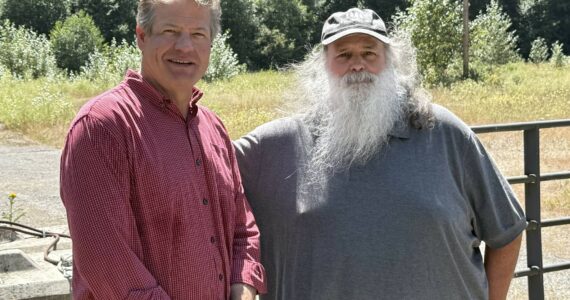 King County Council Vice Chair Reagan Dunn (left) and Bob Baker of Save the Cedar River (right) stand in front of the lot that will no longer be the site of an asphalt plant near the Cedar River. Photo by Drew Dotson/Renton Reporter