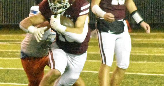 PHOTO BY KEVIN HANSON Running back Paxton Patterson gains some tough yardage after taking a handoff from quarterback Gavin Trachte (10).