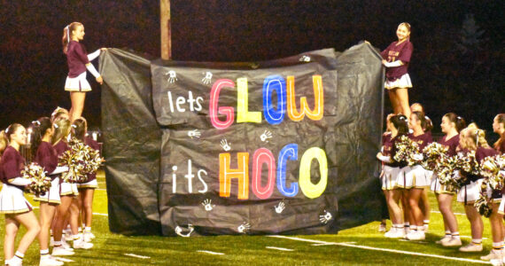 PHOTO BY KEVIN HANSON The Enumclaw cheer squad at the Hornet homecoming game, seconds before the team bursted through the sign.