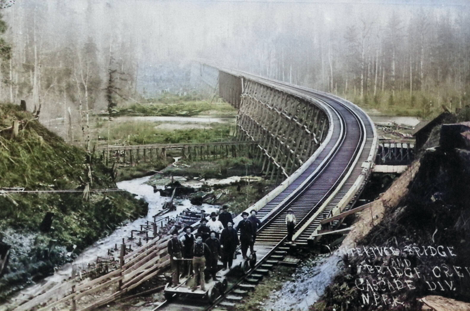 Photo courtesy Enumclaw Plateau Historical Museum 
This 1899 photograph of the recently-completed Norhtern Pacific Railway bridge over the White River looks south from Enumclaw toward Buckley. It was taken by W. S. Walbridge of Slaughter; his lower right inscription reads, “White River Bridge and Bridge Crew, Cascade Division. N.P.R.R.” Boise Creek can be seen to the left of the railroad trestle.