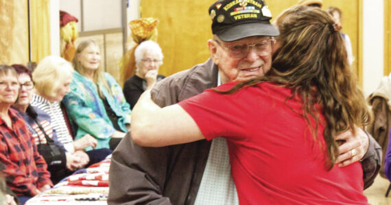 Photos by Ray Miller-Still
Steve Bigger, a Vietnam War veteran, received not just a quilt, but a thank-you hug from Enumclaw Senior Center Recreation Coordinator Rochelle Rogers.