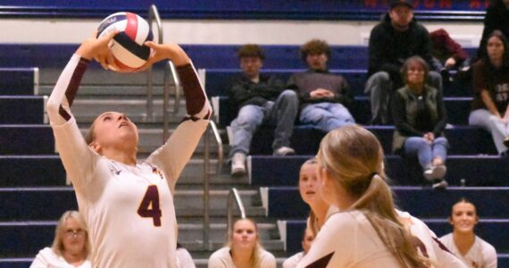 With teammates rushing the net, White River High’s Taylor Arnold sets up a play during her team’s Friday night’s district victory.