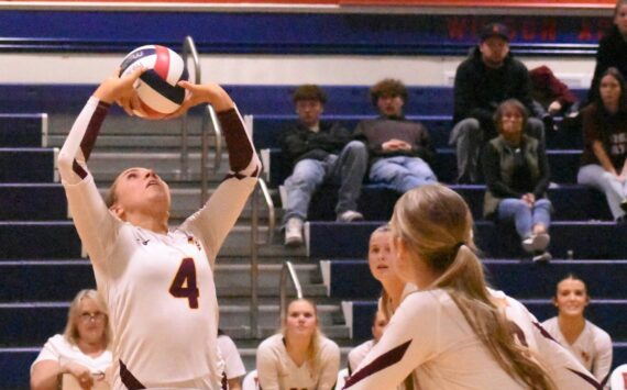 With teammates rushing the net, White River High’s Taylor Arnold sets up a play during her team’s Friday night’s district victory.