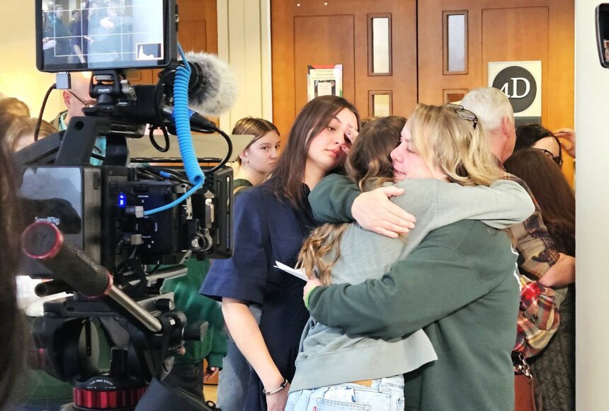 <p>Tanie Valison, the wife of Nick Valison, hugs her daughters after giving a final statement to the media. Photo by Ray Miller-Still</p>