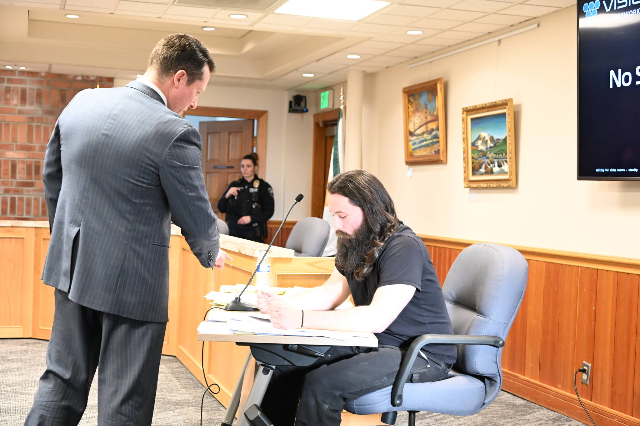 Enumclaw City Prosecutor Will Gunderson presenting defendant Robert Chevrette with a police report before handing it to Sgt. Rich Tison, who was currently testifying. Photo by Ray Miller-Still