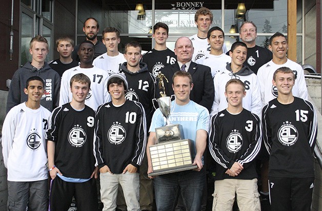 The Bonney Lake Panther soccer team stands with Mayor Neil Johnson on the Justice Center steps. Goalie Moxie Oseland holds the team's state championship trophy