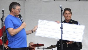Special Events Coordinator David Wells hands Chief Dana Powers a $1