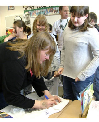 Ingrid Law autographs a T-shirt March 10 at Dieringer Heights Elementary for Caroline Lasko