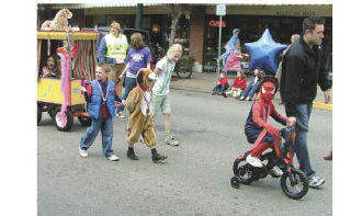 About 75 children dressed in all different types of costumes stroll down Main Street in Sumner during Sunday’s Rotary Club Kids’ Parade.