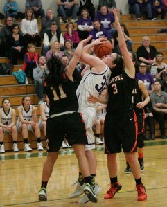 Jamie Lange fights off two Central Kitsap defenders during the 2015 playoffs.