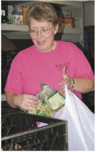 Donna Morrison hand-selects groceries July 8 at Bread of Life Food Bank for a family in need.
