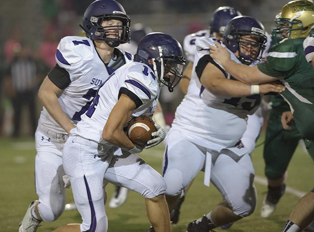 Sumner senior Chase Torgison hands the ball off to junior Josh Riley during Thursdays 31-30 loss to the Auburn Trojans.
