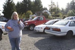Food bank volunteer Carol Bowen listens for instructions via walkie-talkie to direct traffic into and through the building's overflow parking lot.