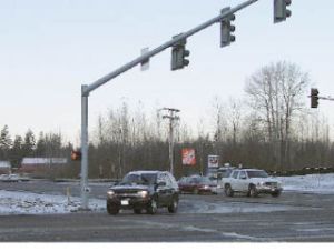 Cars move slowly on the icy streets Monday at the intersection of state Route 410 East and 214th Avenue East.