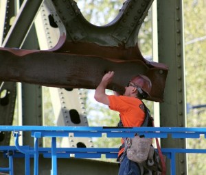 Work crews inspect the bent overhead beam and prepare it for heat straightening on Saturday